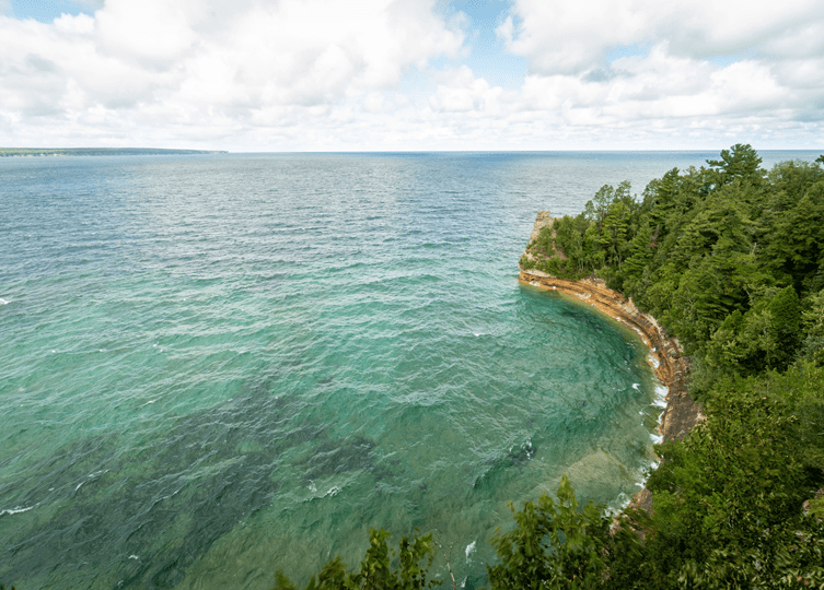 rocky orange shoreline with trees along Lake Superior